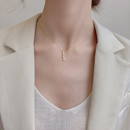 Necklace woman collarbone chain featuring a geometric pendant, styled elegantly with a blazer.