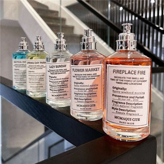 Set of Lazy Weekend Long-Lasting Light Perfume bottles in various scents displayed on a railing indoors