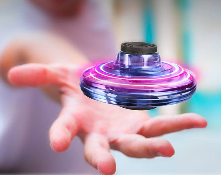 Mini fingertip gyro toy drone with RGB lights spinning above hand for decompression and interactive play