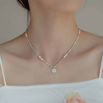 Woman wearing a fashion love pearl necklace with a heart pendant and freshwater pearls on a silver chain
