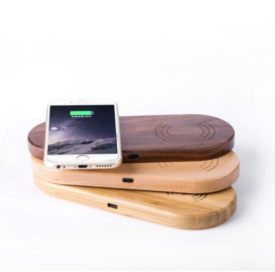 Wooden wireless charger in bamboo, beech, and walnut styles with smartphone charging on top
