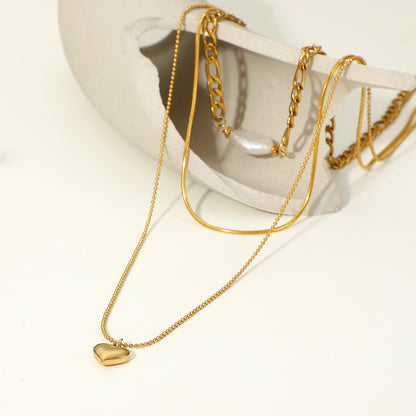 Pearl Heart-Shaped Necklace for women displayed on a stylish pendant holder with gold chains.
