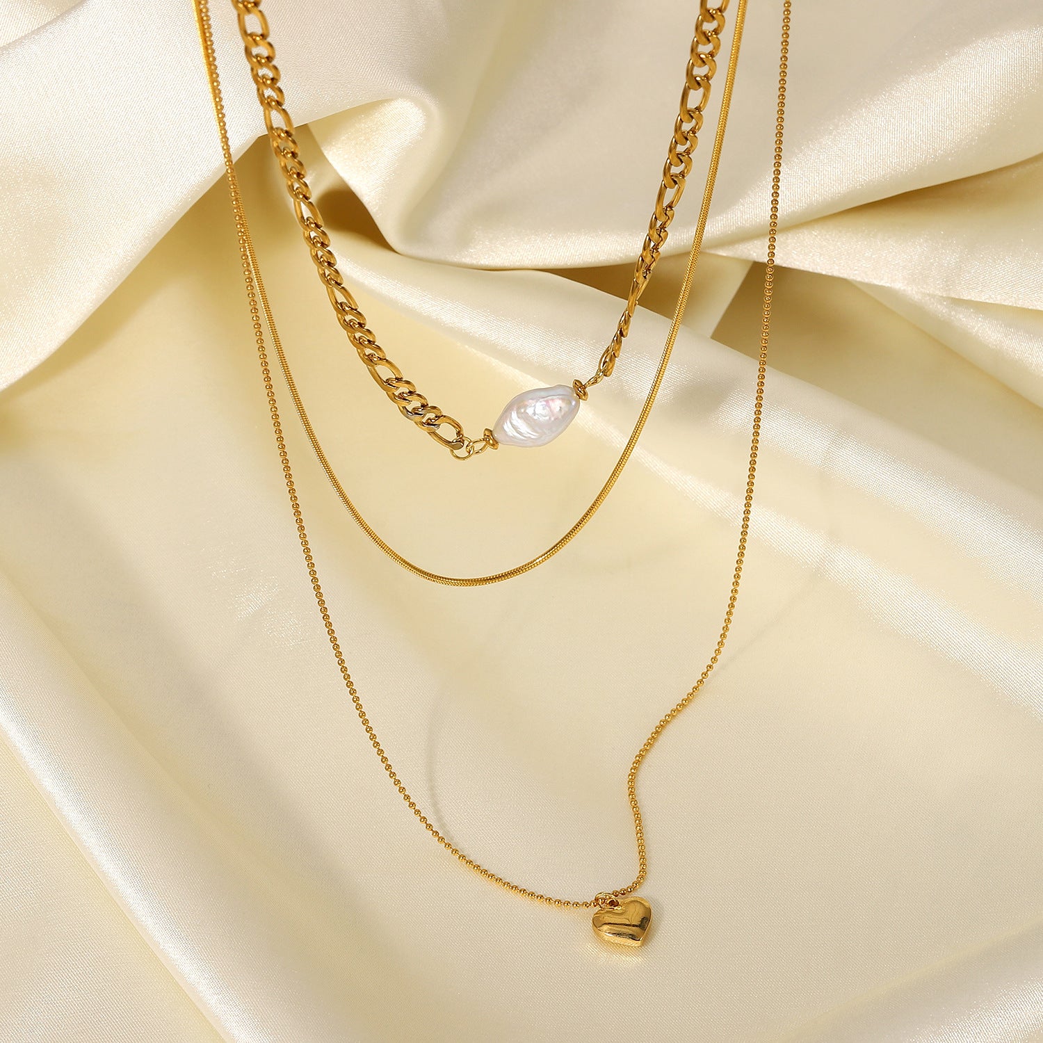 Pearl heart-shaped necklace for women displayed on golden chains, showcasing elegance and sophistication.