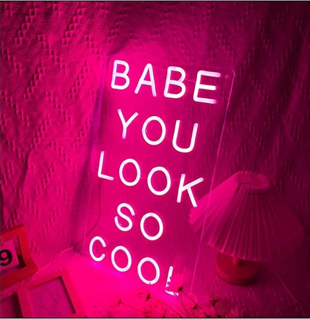 Neon LED light sign reading 'Babe, you look so cool!' in vibrant pink illumination.