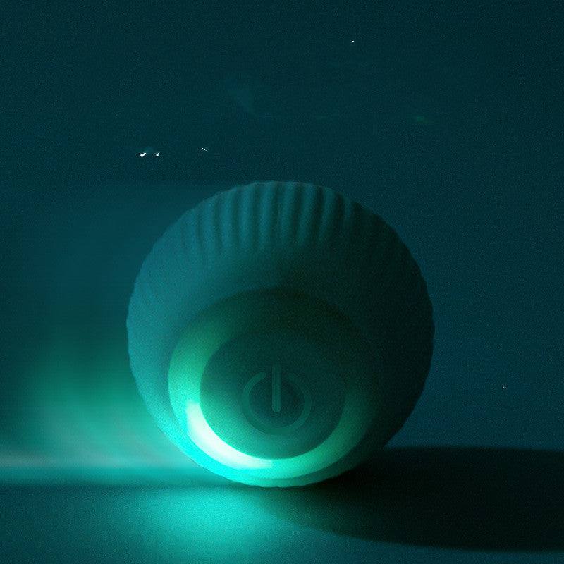Rechargeable gravity electric rolling ball pet toy glowing blue light on dark background
