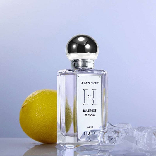 Aromatic citrus perfume bottle with lemon and ice cubes on a light blue background