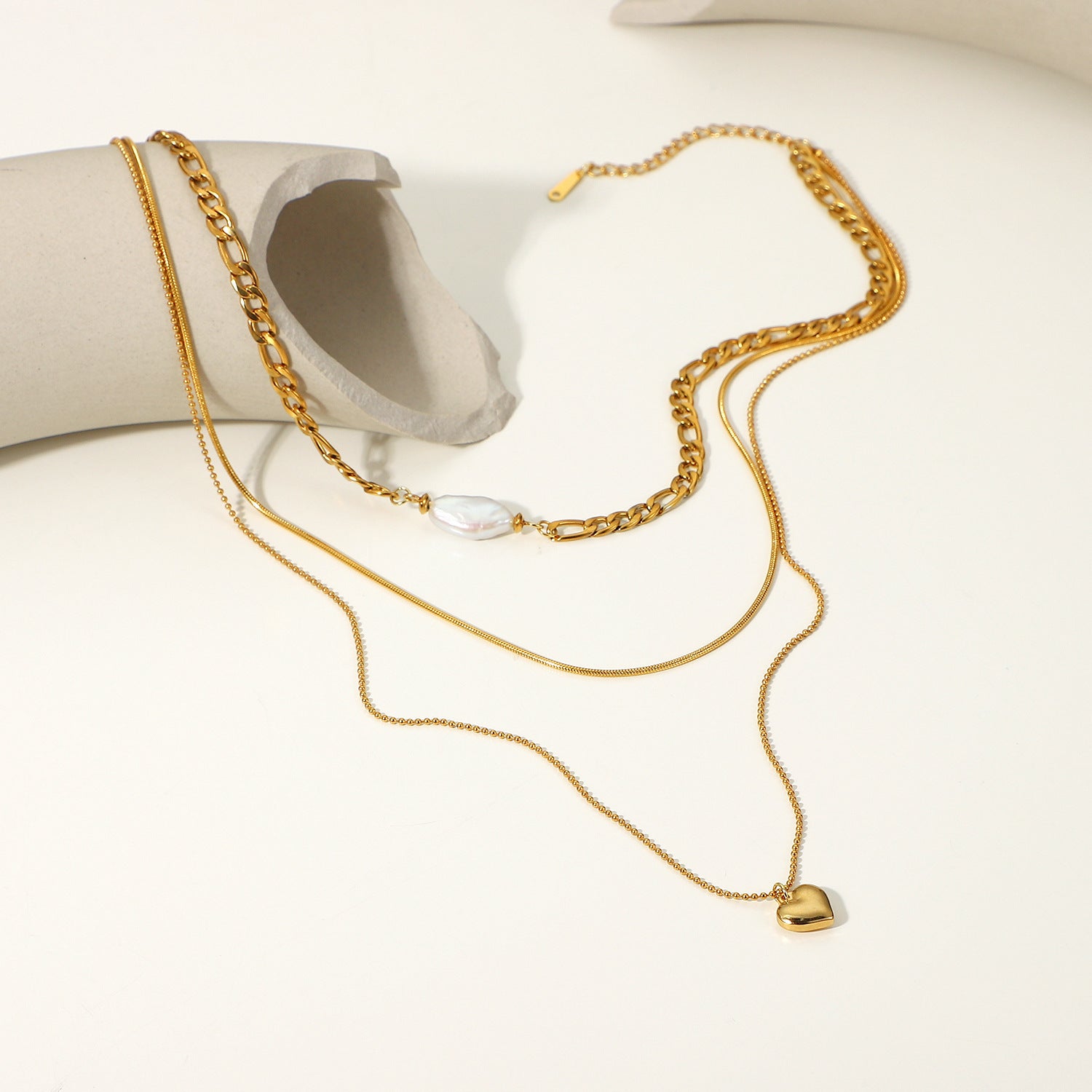Elegant pearl heart-shaped necklace for women, featuring a lustrous pearl centerpiece and gold chain.
